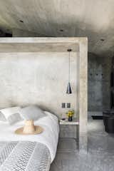 Bedroom, Cement Tile Floor, Bed, Night Stands, Recessed Lighting, Concrete Floor, and Pendant Lighting Beautiful minimal interiors are featured throughout.  Photos from A Commanding Mexican Home of Stone and Concrete Is For Sale