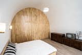 Bedroom, Pendant Lighting, Bed, Medium Hardwood Floor, Dresser, Storage, and Wall Lighting The bedroom for the client's grandmother.  Photo 10 of 26 in An Old Cave Dwelling in Central China Is Transformed Into a Stylish Home