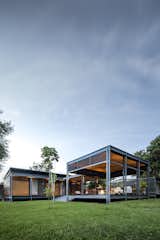The the warm wood siding is juxtaposed against the industrial grey steel frame of the structure.