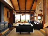 Living, Carpet, Sofa, Pendant, Wood Burning, Chair, and Wall The living room features ample glazing and an exposed beam ceiling.  Living Sofa Wood Burning Wall Carpet Photos from A Contemporary Beach Retreat on California's Central Coast Asks $2.3M