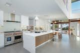 Kitchen, Refrigerator, Slate Floor, Pendant Lighting, Range Hood, White Cabinet, Range, Recessed Lighting, Undermount Sink, Wall Oven, and Beverage Center The updated open kitchen features state of the art appliances.  Photo 5 of 15 in A Renovated Harry Gesner–Designed Midcentury in L.A. Wants $9.4M
