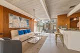Living Room, Chair, Sofa, Coffee Tables, Pendant Lighting, Stools, Bar, and Rug Floor The walls are original Philippine mahogany and offer authentic midcentury charm.  Photos from An Elegant Eichler Hits the Market at $1.15M in Northern California
