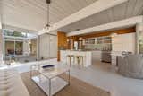 Kitchen, Drop In, Dishwasher, Pendant, Refrigerator, Glass Tile, and White The kitchen is bright thanks to the central atrium and the open-plan design.  Kitchen Glass Tile Pendant Drop In Photos from An Elegant Eichler Hits the Market at $1.15M in Northern California