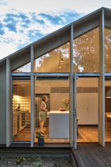 Exterior, Wood Siding Material, House Building Type, Glass Siding Material, and Saltbox RoofLine Floor-to-ceiling glass with sliding glass doors allow access to the decked outdoor space, covered by the roof's overhang.  Photo 3 of 12 in A Contemporary Extension Gives This Australian Home a New Face