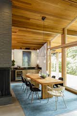 Dining, Table, Corner, Chair, Pendant, Storage, Rug, and Bar The design team exposed the original brick highlighting the warmth of the original wood ceiling.  Dining Chair Corner Photos from Before & After: A Midcentury Lakeside Home Receives a Stunning New Look