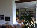 A view of the dining room area from the living room before the renovations. Drywall covers the fireplace and a built-in bookcase is at the rear.  Photo 4 of 11 in Before & After: A Midcentury Lakeside Home Receives a Stunning New Look