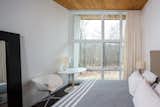 Bedroom, Night Stands, Table Lighting, Bed, Chair, and Dark Hardwood Floor Two bedrooms and a full bath are located on the main floor, with the master bedroom suite on the second level. 

  Photo 8 of 10 in An Eco-Friendly Connecticut Home Wants $650K