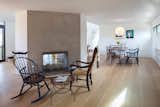 Living Room, Light Hardwood Floor, Chair, Two-Sided Fireplace, Table, and End Tables The backside of the home's double-sided fireplace.  Photo 6 of 14 in A Renovated Farmhouse in the Hamptons Hits the Market at $2.8M