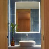 Bath Room, Marble Counter, Accent Lighting, Vessel Sink, and Ceramic Tile Wall A deep earthy blue tile plays off the richness of the wood in this bathroom.  Photo 16 of 17 in Color Unites With Texture to Make This Brazilian Abode Appear Much Larger and Brighter