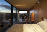 Bedroom, Bed, Slate Floor, Chair, and Track Lighting The nightscape is equally stunning.  Photos from A New Prefab Hotel in Uruguay Seems to Melt Into the Landscape