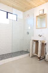 A glass-enclosed shower helps increased the sense of space in the tiny bathroom.