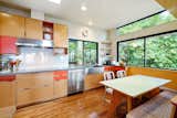 Kitchen, Wood Cabinet, Colorful Cabinet, Dishwasher, Medium Hardwood Floor, Drop In Sink, Subway Tile Backsplashe, Recessed Lighting, Cooktops, and Pendant Lighting The kitchen also has a strong sense of the outdoors.  Photo 10 of 17 in This Knockout Midcentury in the Bay Area Will Run You $1.9M