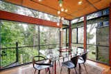 Dining Room, Table, Medium Hardwood Floor, Chair, Rug Floor, Recessed Lighting, and Pendant Lighting The dining room has the sense of being in a glass-enclosed structure in the woods.  Photo 6 of 17 in This Knockout Midcentury in the Bay Area Will Run You $1.9M