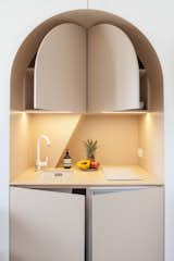 Kitchen, Refrigerator, White, Cooktops, Colorful, Accent, and Undermount Pop-out doors reveal storage space and a tiny refrigerator.  Kitchen Undermount White Cooktops Accent Photos from This Tiny Home in Paris Unfolds Like a Children's Pop-Up Book