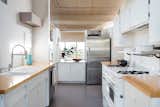 Kitchen, White, Refrigerator, Range, Drop In, Wood, Terrazzo, Wall Oven, and Dishwasher The kitchen is opposite the dining area.  Kitchen White Refrigerator Terrazzo Dishwasher Photos from Own a Charismatic L.A. Midcentury Designed by Rudolph Schindler For $1.8M