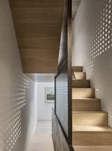 A perforated steel plate&nbsp;forms a wall between the staircase and the room.