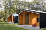 Exterior, Metal Roof Material, Wood Siding Material, and Hipped RoofLine The dark stained cedar exteriors, and galvanized metal roofs, house bright, warm interiors.  Photo 3 of 9 in These Modern Artist Studios in the Connecticut Countryside Radiate Inspiration