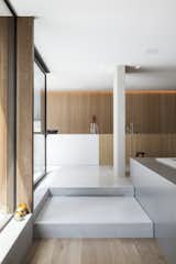 Hallway, Medium Hardwood Floor, and Concrete Floor A few steps down from the kitchen is the built-in dining area.   Photo 7 of 16 in This Glass Pied-à-Terre Is Hidden in a Belgian Garden