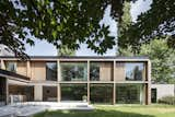 Exterior, Flat RoofLine, House Building Type, Wood Siding Material, Glass Siding Material, and Brick Siding Material The ground floor follows an L-shaped plan, and is accessed via a tiered concrete terrace.  Photo 2 of 16 in This Glass Pied-à-Terre Is Hidden in a Belgian Garden