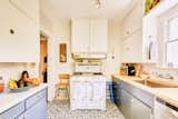 A charming kitchen features graphic floor tiles and is equipped with a vintage Wedgwood stove.