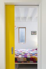 A guest room is tucked behind a primary yellow pocket door on the ground floor.