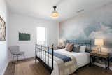 Bedroom, Medium Hardwood Floor, Bed, Night Stands, Chair, Ceiling Lighting, Rug Floor, and Table Lighting One of the three bedrooms features mural-type wallpaper from Anewall.  Photos from An Updated Spanish-Style Abode with an Artist Studio Hits the Market at $1.1M in L.A.