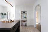 Kitchen, Concrete, Ceramic Tile, Refrigerator, Recessed, Pendant, and White The custom cabinetry includes ample storage and a convenient mini desk.  Kitchen Pendant Ceramic Tile White Photos from An Updated Spanish-Style Abode with an Artist Studio Hits the Market at $1.1M in L.A.