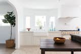 Kitchen, White Cabinet, Range Hood, Range, Drop In Sink, Ceramic Tile Floor, Concrete Counter, and Recessed Lighting An arched doorway separates the kitchen from the dining room, allowing for easy entertaining. 

  Photo 6 of 19 in Kitchens by Hunter Lloyd from An Updated Spanish-Style Abode with an Artist Studio Hits the Market at $1.1M in L.A.