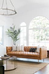 Living Room, Rug Floor, Sofa, Coffee Tables, Medium Hardwood Floor, and Pendant Lighting  The large arched windows allow ample natural light to flood the interiors. 

  Photo 3 of 20 in An Updated Spanish-Style Abode with an Artist Studio Hits the Market at $1.1M in L.A.