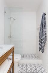 Bath, One Piece, Marble, Porcelain Tile, Open, Recessed, and Undermount The updated bathroom in the hallway has been fitted with geometric floor tiles. 

  Bath Open One Piece Undermount Photos from An Updated Spanish-Style Abode with an Artist Studio Hits the Market at $1.1M in L.A.