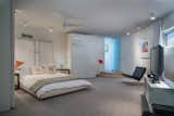 Bedroom, Bed, Ceiling Lighting, Carpet Floor, Night Stands, Chair, and Table Lighting The master suite features an ensuite bathroom.

  Photos from A Circular Midcentury Gem in Florida Hits the Market at $1M