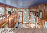 Living Room, Chair, Sofa, Medium Hardwood Floor, Recessed Lighting, Shelves, and Wall Lighting "One great thing about tiny homes is that you can do all the details," explains Latimer.  Photo 8 of 12 in This Tiny Home and Writing Studio Was Invented for a Children’s Author