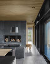 The minimalist material palette is picked up on the interiors as well, where a black concrete fireplace plays off the polished aggregate concrete floors.&nbsp;
