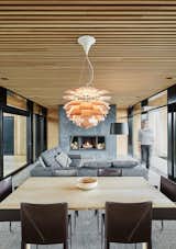 Living, Concrete, Pendant, Standard Layout, Wood Burning, Sectional, Chair, Table, Recessed, and Floor The use of wood softens the industrial feel of the concrete.  Living Pendant Concrete Table Floor Photos from A Timber-and-Concrete Summer House in Iceland Boasts Breathtaking Views