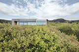 Exterior, Concrete Siding Material, House Building Type, Glass Siding Material, Flat RoofLine, and Wood Siding Material Set on a ridge overlooking a deep ravine, this summer home in Southern Iceland is surrounded by awe-inspiring scenery.  Photos from 35 Modern Homes That Make the Case for Concrete