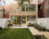 Although the home's historic front facade needed to be preserved, the back of the residence was ripe for a remodel. The architects cladded the exterior in eastern cedar. The wood is offset with large expanses of glass, as well as yellow accents to add a playful atmosphere. 

  Photo 3 of 21 in Before & After: A Century-Old Row House in Montreal Gets a Glorious Renovation