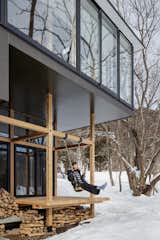 Partially enclosed, the exterior platform features an outdoor swing that is suspended from the timber-framed porch.

