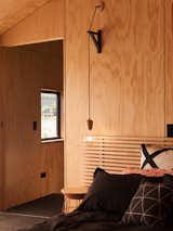 The bedrooms maintain the same look as the rest of the home with the use of plywood and black accents.&nbsp;&nbsp;