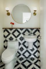 The powder room received a simple, yet stunning transformation with white paint, modern sconces from Cedar & Moss, and the addition of graphic black and white cement tile from Ann Sacks that wraps the wall.

