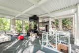 Living Room, Coffee Tables, Chair, Pendant Lighting, Sectional, Ottomans, and Two-Sided Fireplace An overview of the open-plan layout.  Photo 6 of 12 in Own This Iconic Glass Home in Salt Lake City For $950K