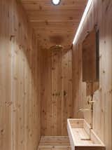Bath Room, Open Shower, Drop In Sink, Wood Counter, Light Hardwood Floor, and Recessed Lighting The sauna-like bathroom is made of cedar and features fixtures from VOLA.

  Photo 7 of 10 in This Sleek, Angular Tiny Home Is Not Your Average A-Frame Cabin