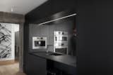 Kitchen, Ceiling Lighting, Wall Oven, Microwave, Undermount Sink, and Light Hardwood Floor The efficiently designed kitchen has been crafted by local kitchen brand À Hauteur d’homme. 

  Photo 6 of 18 in An Iconic T-Shaped Apartment Receives a Modern Makeover