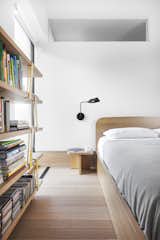 Bedroom, Bed, Wall Lighting, Shelves, Light Hardwood Floor, and Night Stands The bedroom is predominately oak with a custom-designed bed and nightstand. The lighting in this room is also by Sangaré.

  Photo 11 of 18 in An Iconic T-Shaped Apartment Receives a Modern Makeover