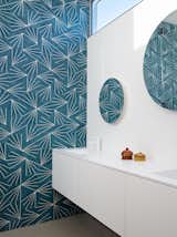 Bright, colorful wallpaper adds a fun touch of midcentury vibes to the bathroom.