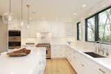 Kitchen, Quartzite, Recessed, Range, Light Hardwood, White, Marble, Pendant, Undermount, and Wall Oven The transformed kitchen shows off how bright the home is now.   Kitchen White Quartzite Pendant Photos from An Iconic Portland Midcentury Is Seeking a New Owner For $1.6M