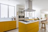 Bright yellow cabinets in this kitchen add a playful, fun touch, while also maintaining a sleek, contemporary look.&nbsp;
