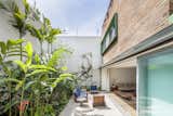 Outdoor, Vertical Fences, Wall, Gardens, Concrete Fences, Wall, Large Patio, Porch, Deck, and Back Yard The garden effortlessly integrates the outdoors into the living space.

  Photos from Lush Gardens Infuse Tropical Vibes in This Chic Brazilian Home
