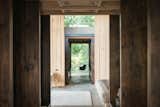 Hallway and Concrete Floor Interior spaces appear to flow seamlessly to the outside as materials continue from inside to out through invisible sheets of glass.  Photos from A Mesmerizing Cabin in Puget Sound Evolves Over Several Decades