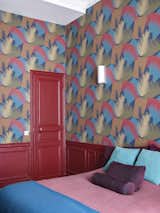 Bold choices for the guest room include Cole &amp; Son's Deco Palm Wallpaper in red and blue.