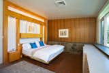 The master bedroom has wood paneling and built-in shelving.